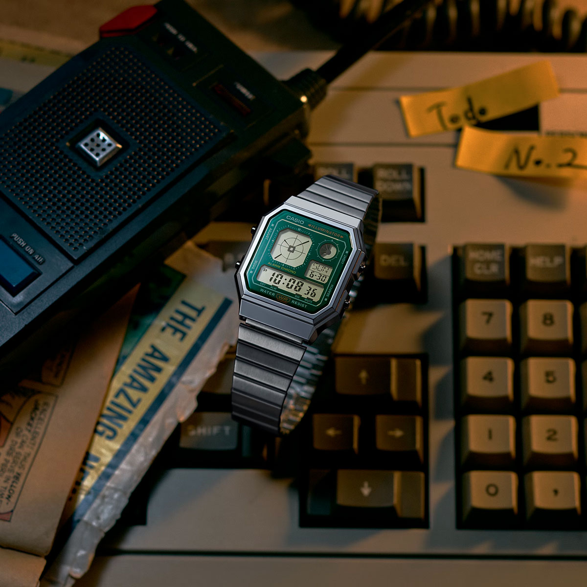 Casio A130WE-3A с зелёным циферблатом на клавиатуре рядом с диктофоном